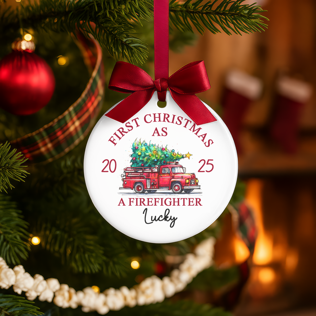 Christmas ornament with red truck and tree design, hanging on a decorated tree.