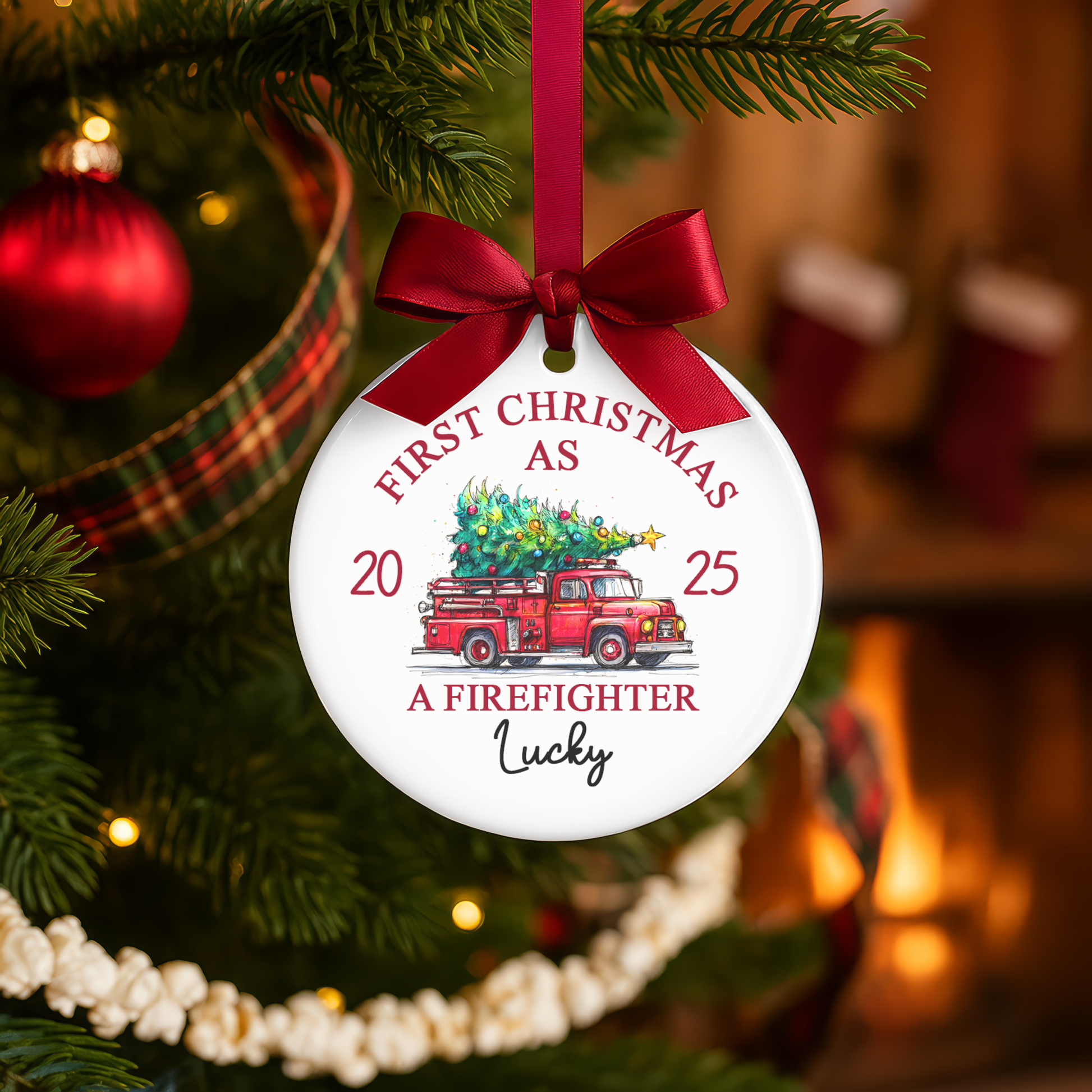 Christmas ornament with red truck and tree design, hanging on a decorated tree.